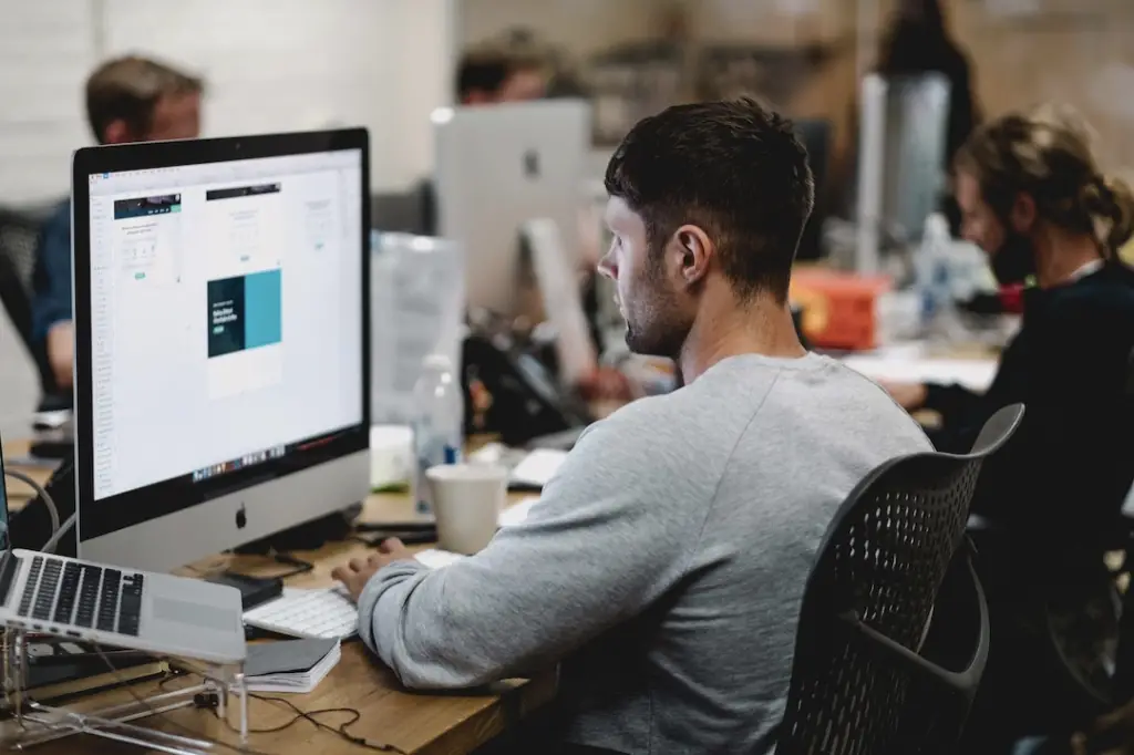 A man in an office researching customer journey orchestration on his computer